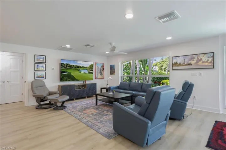 Living area featuring light wood finished floors and recessed lighting