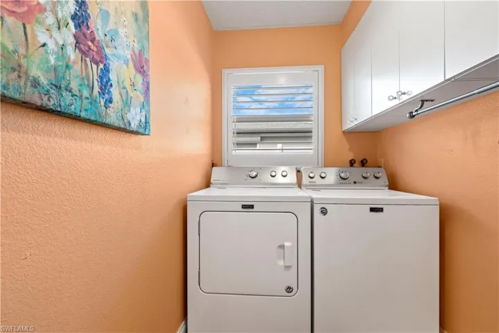 Laundry room featuring cabinets and washing machine and clothes dryer