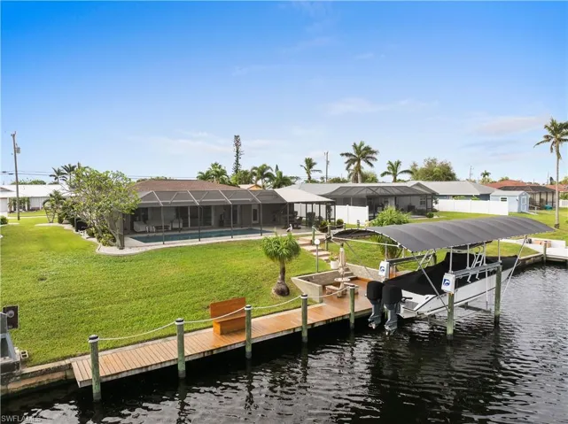Dock area featuring the backyard, a water view, and a swimming pool