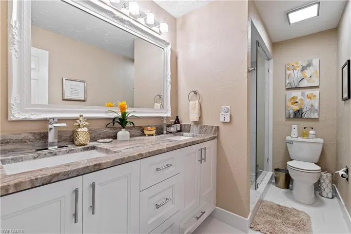 Guest Bathroom with tile flooring, vanity, toilet and shower