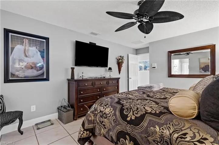 Primary Bedroom with ceiling fan, light tile patterned flooring