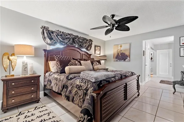 Tiled primary bedroom with ceiling fan