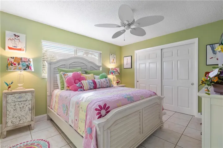 Tiled second bedroom featuring ceiling fan, and a closet