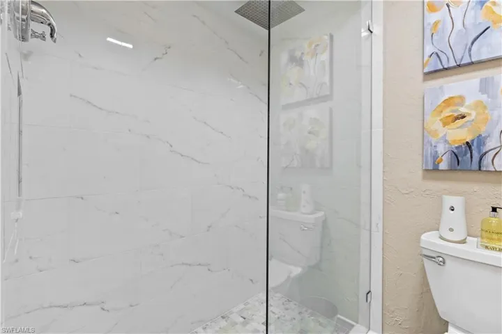 Bathroom featuring a tile shower and toilet