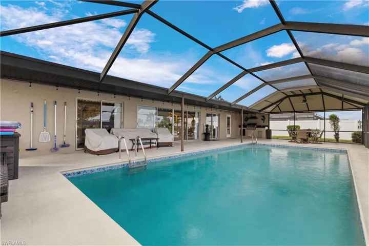 Corner view of pool with a patio area and a lanai