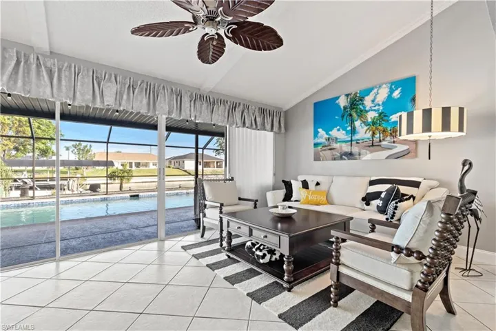 Tiled family room featuring ceiling fan and vaulted ceiling