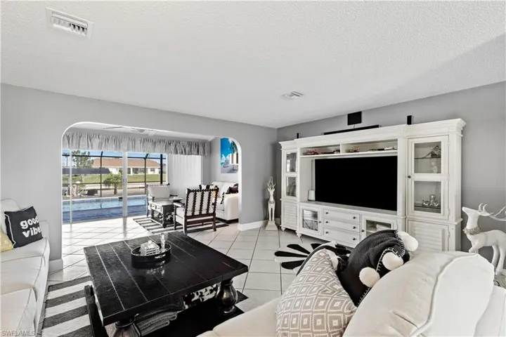 Living room with light tile patterned flooring and a textured ceiling