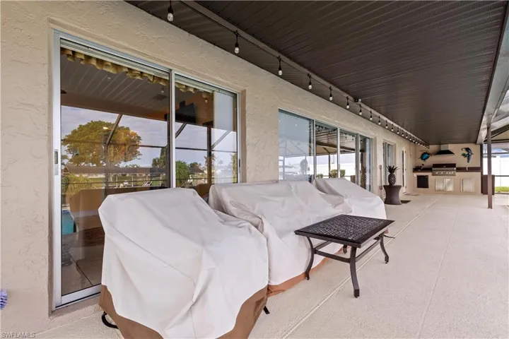 Long view of lanai / terrace with an outdoor kitchen
