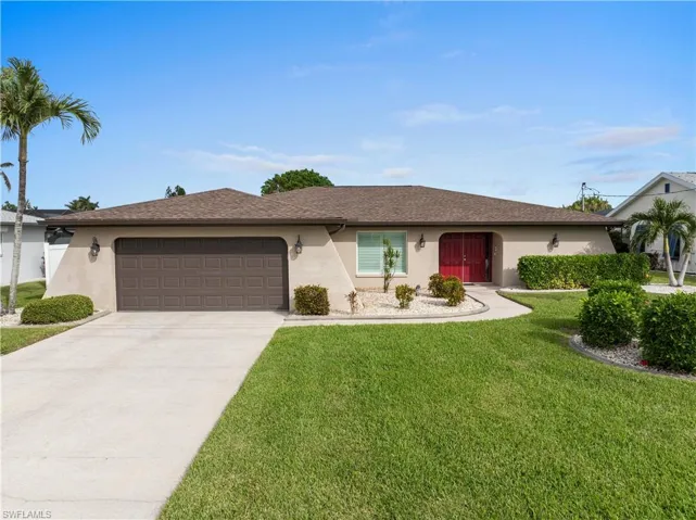 Ranch-style house with a garage and manicured front lawn