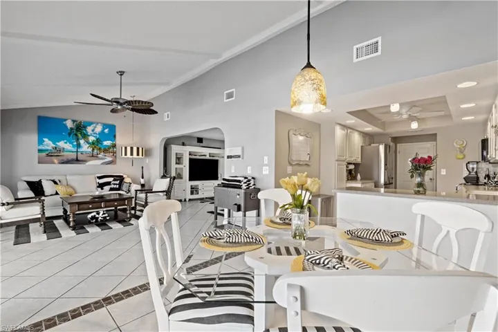 Dinette with sloped ceiling, ceiling fan, and light tile patterned flooring
