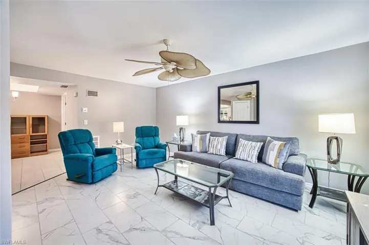 Living area featuring light marble finish flooring and ceiling fan