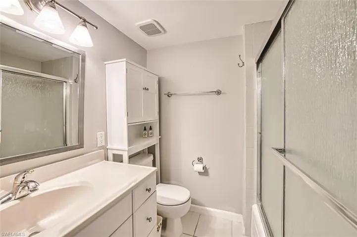 Bathroom with light tile patterned floors and vanity
