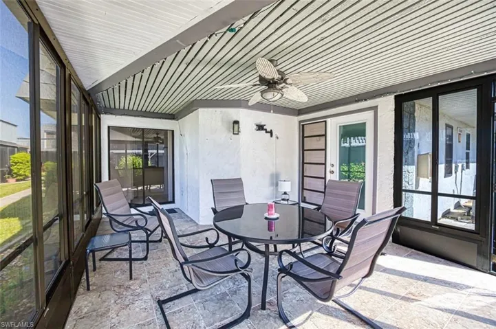 Sunroom / solarium with ceiling fan, outdoor dining area, and a patio