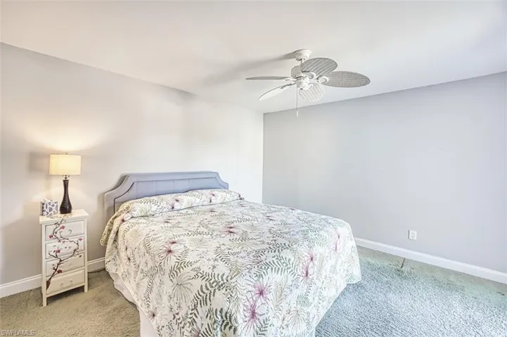 Bedroom with light colored carpet and a ceiling fan