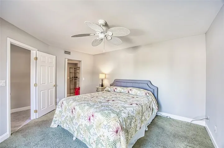 Carpeted bedroom with baseboards and a ceiling fan
