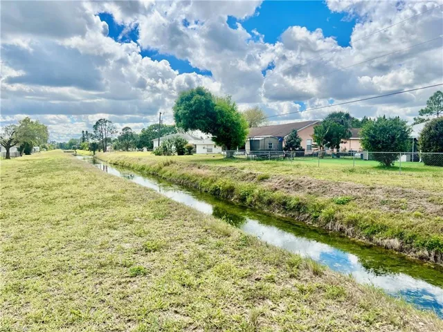 View of yard featuring a water view and fence