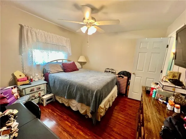 Bedroom with shiny wood laminate floors and a ceiling fan