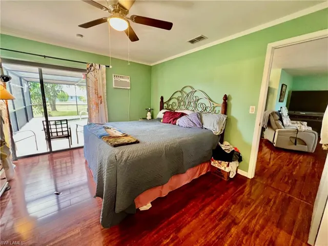Primary bedroom with sliders to the pool area and crown molding.
