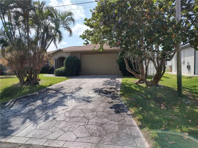 View of front facade featuring a garage and a front yard