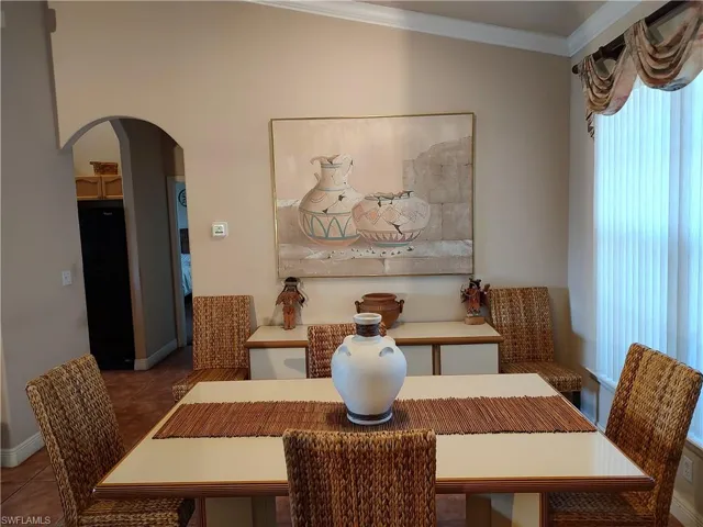 Dining area with tile patterned floors and ornamental molding