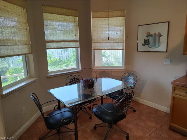 Tiled dining space featuring a wealth of natural light