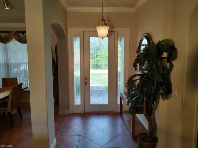 Tiled entryway featuring ornamental molding