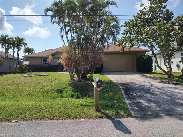 View of front facade with a garage and a front lawn