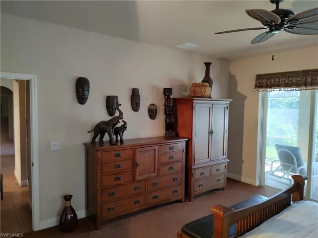 Bedroom featuring ceiling fan, access to exterior, and light carpet