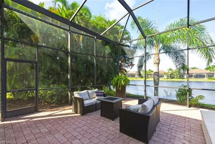 View of patio with a lanai, an outdoor living space, a water view, and a sunroom