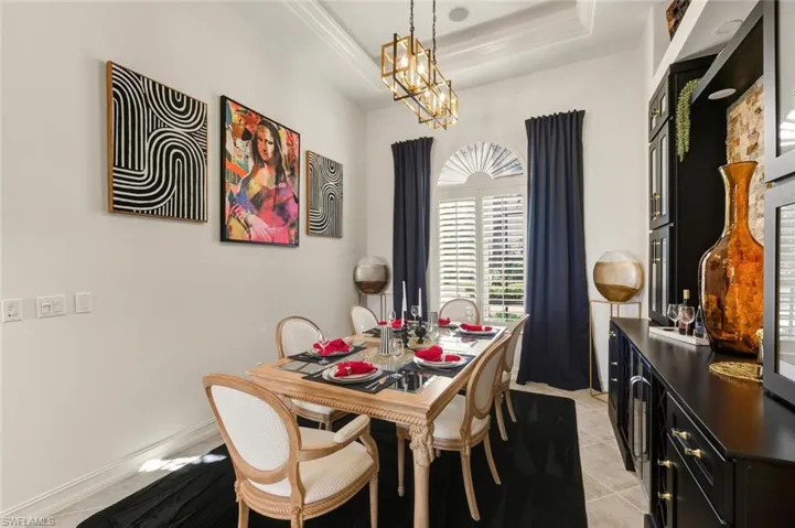 Dining area featuring light tile patterned flooring and a chandelier