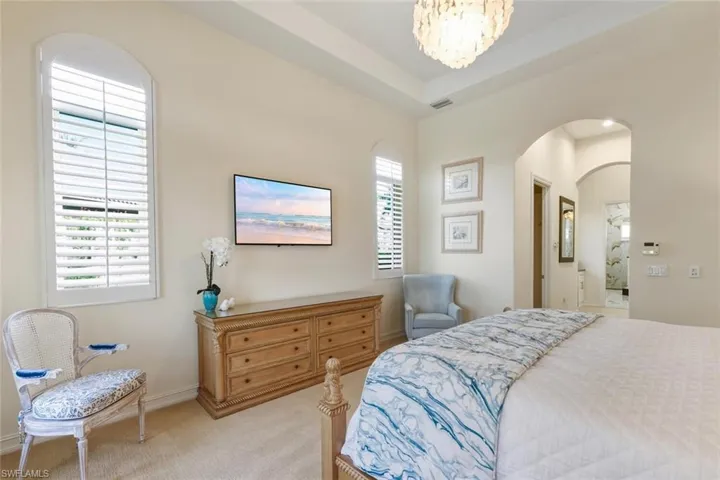 Bedroom featuring carpet flooring, a chandelier, and a tray ceiling