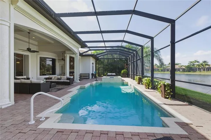 View of pool with a lanai, outdoor lounge area, a sunroom, a patio, and a pool with connected hot tub