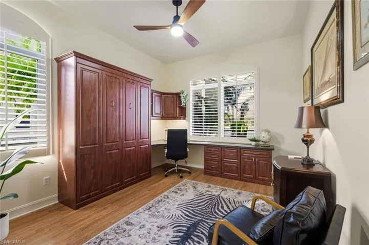 Office with ceiling fan, healthy amount of natural light, light wood-type flooring, and built in desk