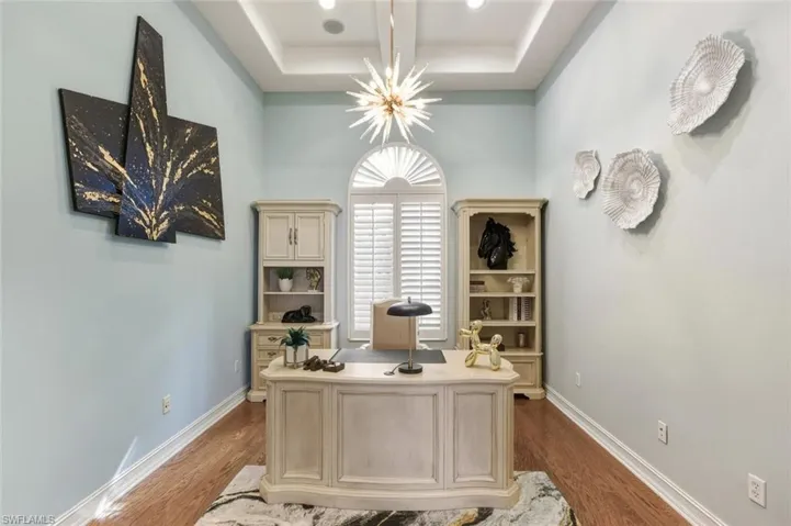 Office space featuring wood finished floors and a chandelier