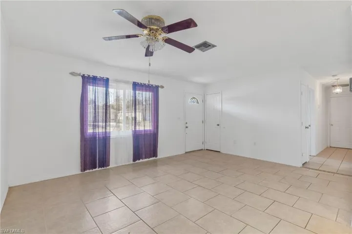 Unfurnished room featuring a ceiling fan and light tile patterned floors