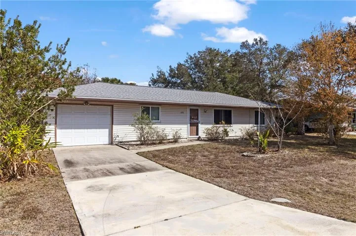Single story home with driveway, an attached garage, and a shingled roof