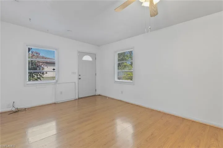 Foyer featuring healthy amount of natural light, ceiling fan, and light wood finished floors