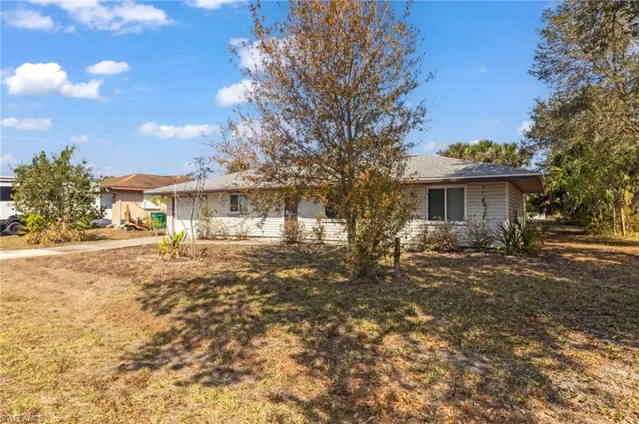 Ranch-style house featuring an attached garage, a front yard, and driveway