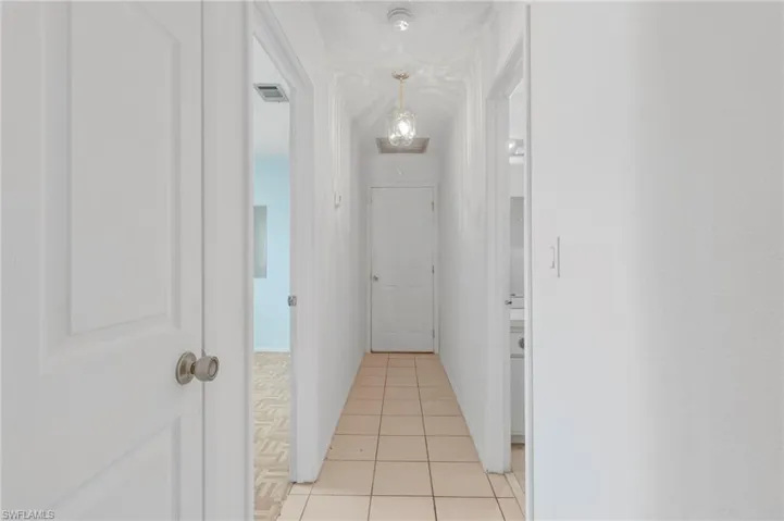 Corridor featuring light tile patterned floors