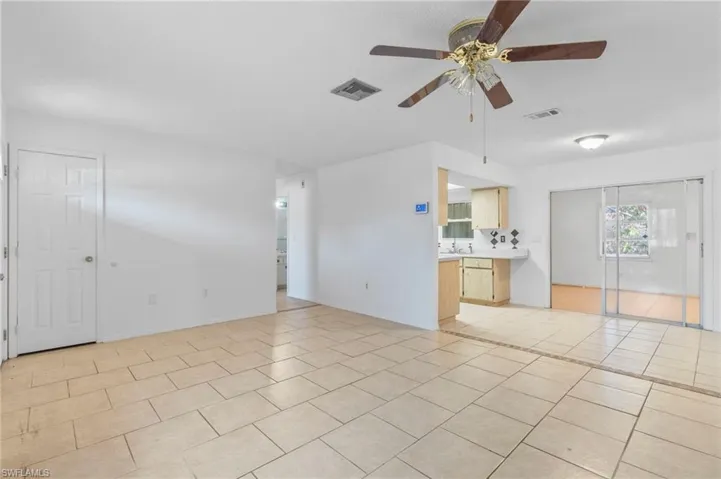 Unfurnished living room featuring a ceiling fan and light tile patterned floors