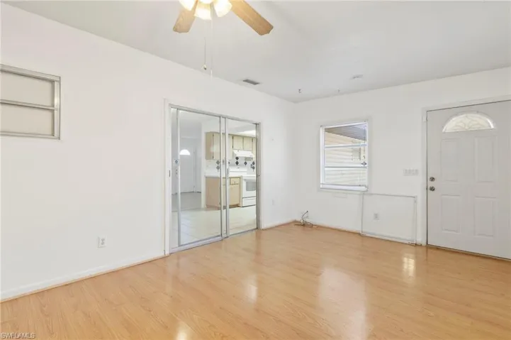 Foyer with light wood finished floors and a ceiling fan