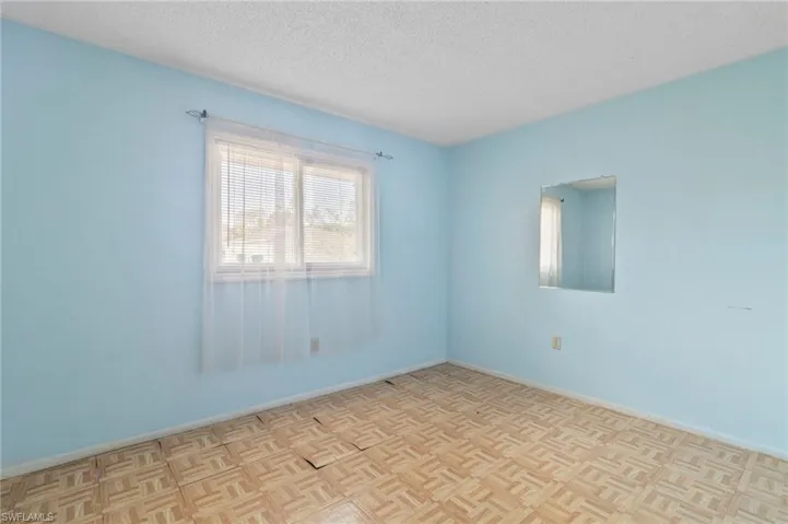 Spare room with parquet flooring and a textured ceiling
