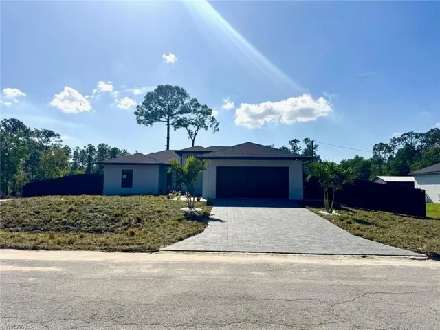 View of front facade with decorative driveway and a garage
