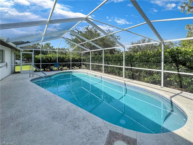 View of swimming pool with a patio area and a lanai