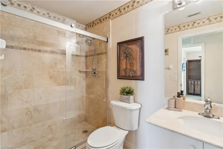 Bathroom with vanity, toilet, and an enclosed shower