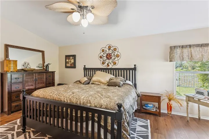 Bedroom featuring wood-type flooring, vaulted ceiling, and ceiling fan