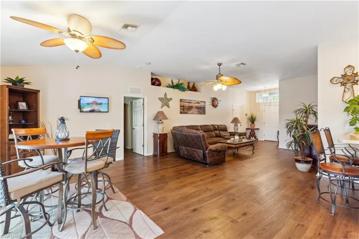 Living room featuring ceiling fan, vaulted ceiling, and wood-type flooring