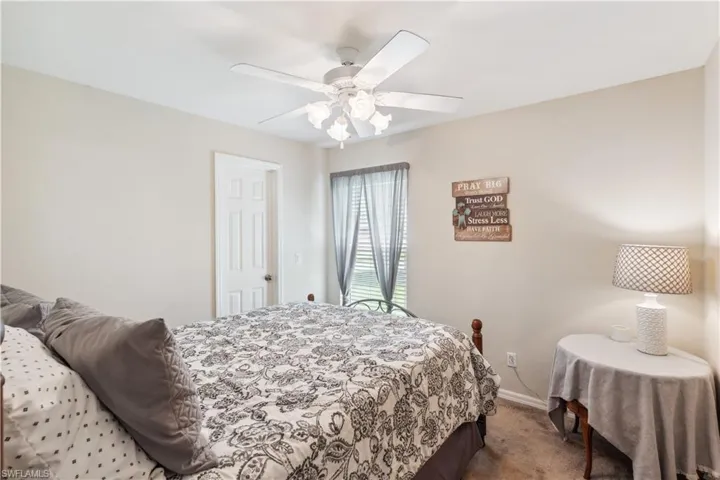 Bedroom with ceiling fan and light colored carpet