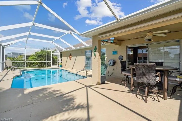 View of swimming pool featuring a lanai, ceiling fan, and a patio area