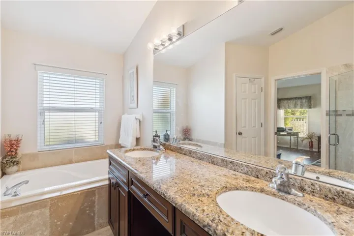 Bathroom featuring vanity, lofted ceiling, and a wealth of natural light